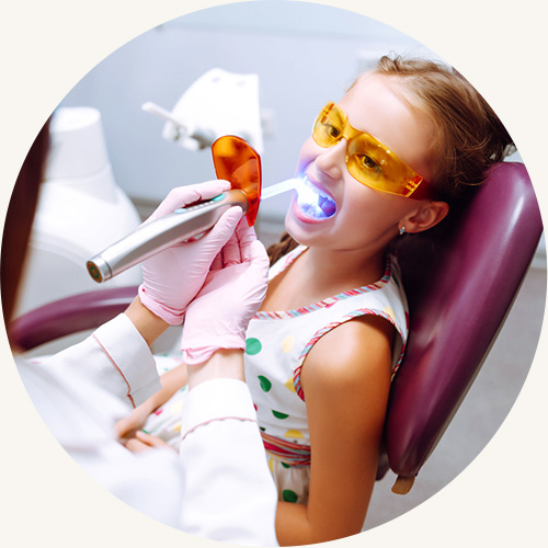 Girl on dental chair getting dental sealants