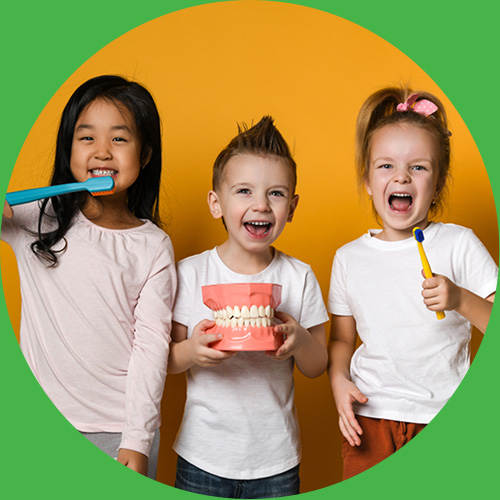 Kids holding dental model and fake toothbrush